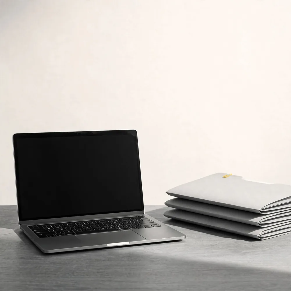 A laptop beside stacked folders